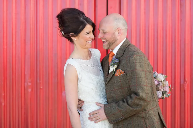 Kinkell Byre wedding - Colin and Sarah in front of the red barn door