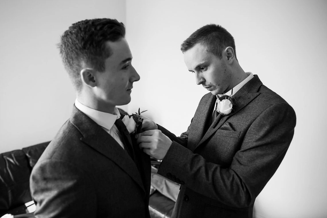 groom preparations buttonholes on jackets