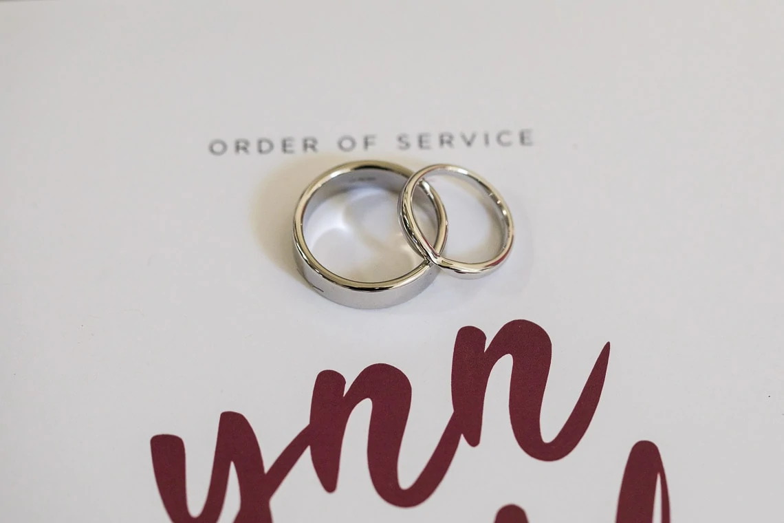 bride and groom wedding rings placed on the order of service