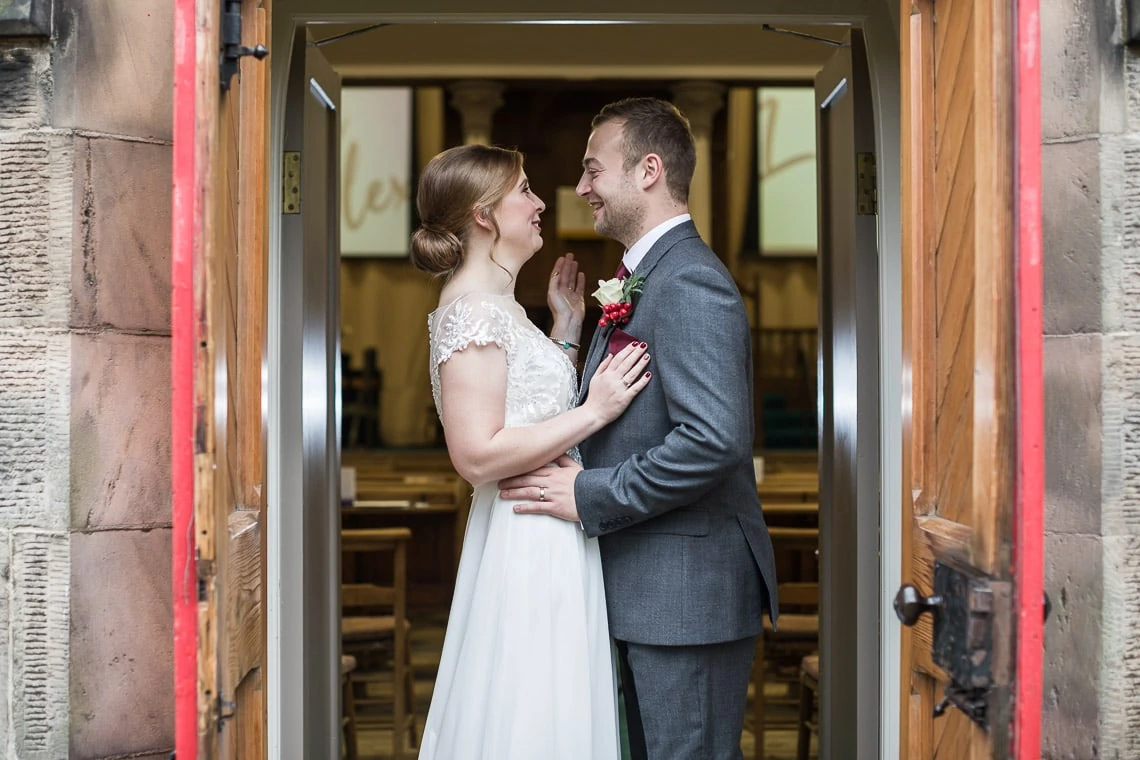 newlyweds embrace at the back door of Liberton Kirk