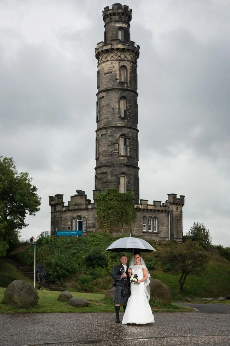 newlyweds on Calton Hill with Nelson Monument in the background