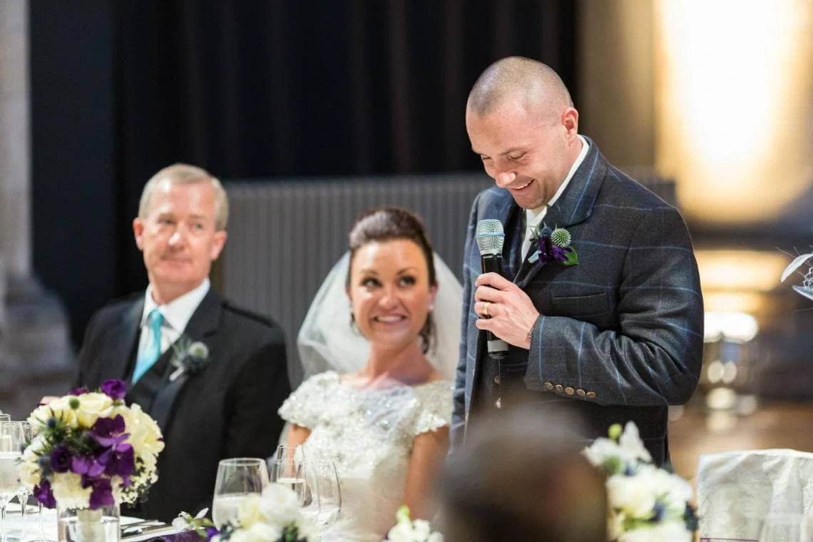 bride smiles during groom's speech