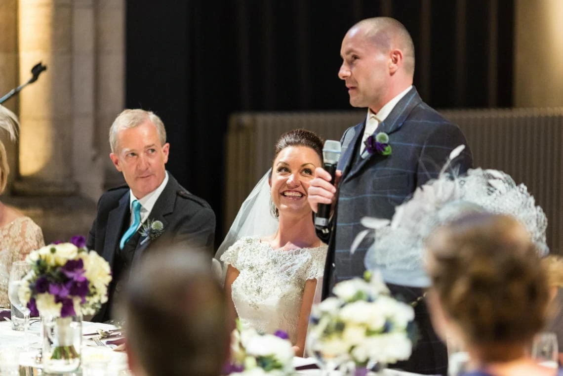 bride smiling as she watches groom's speech