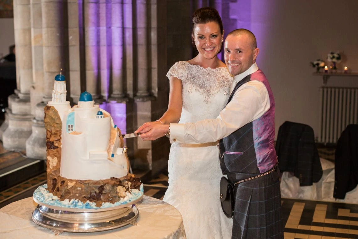 newlyweds cut their Santorini wedding cake