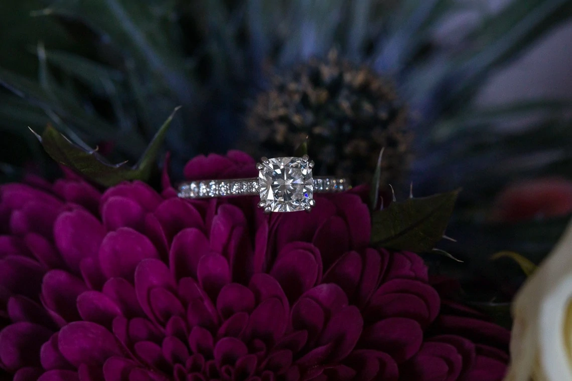 diamond wedding ring sat on bridal bouquet