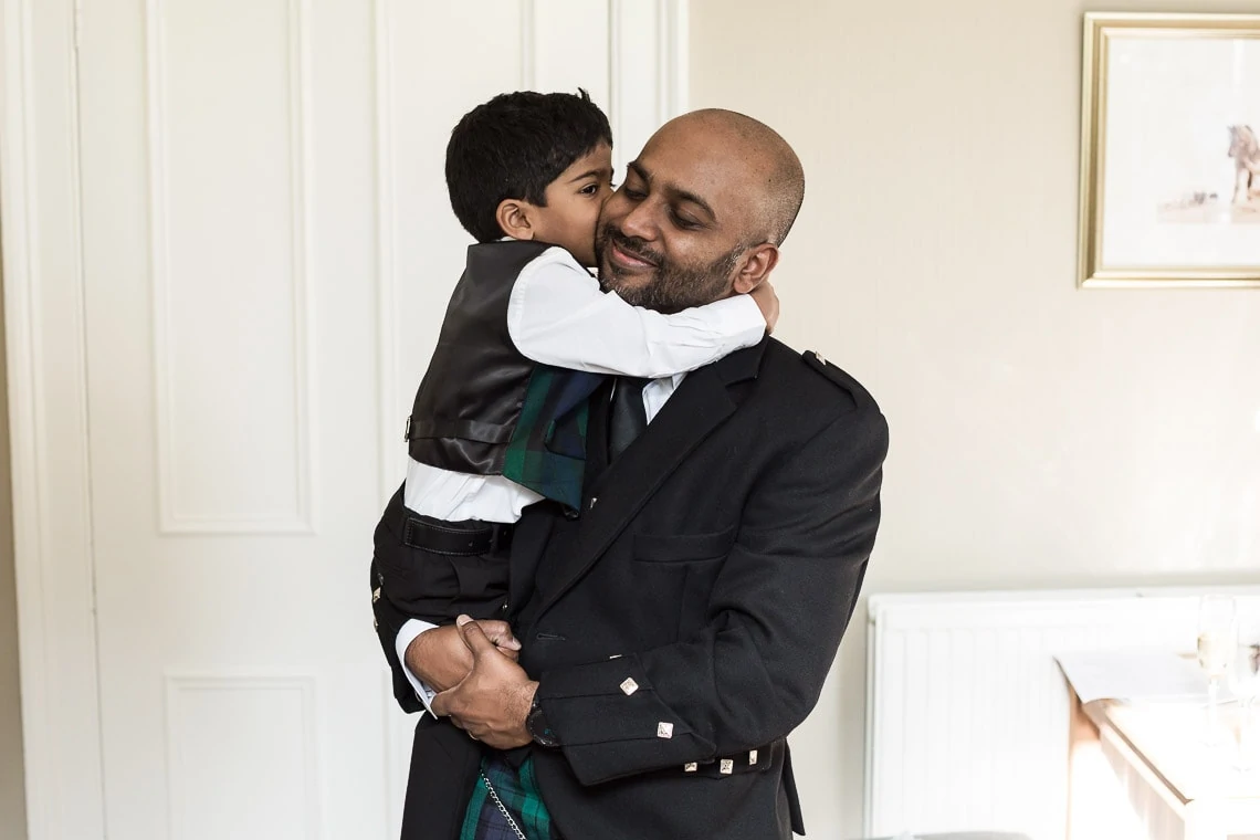 Groomsman cuddles his young son
