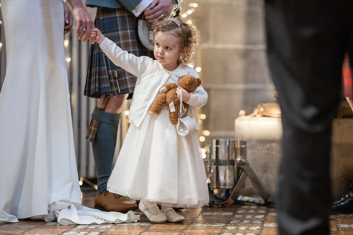 bride holds her flower girl daughter's hand during her naming ceremony