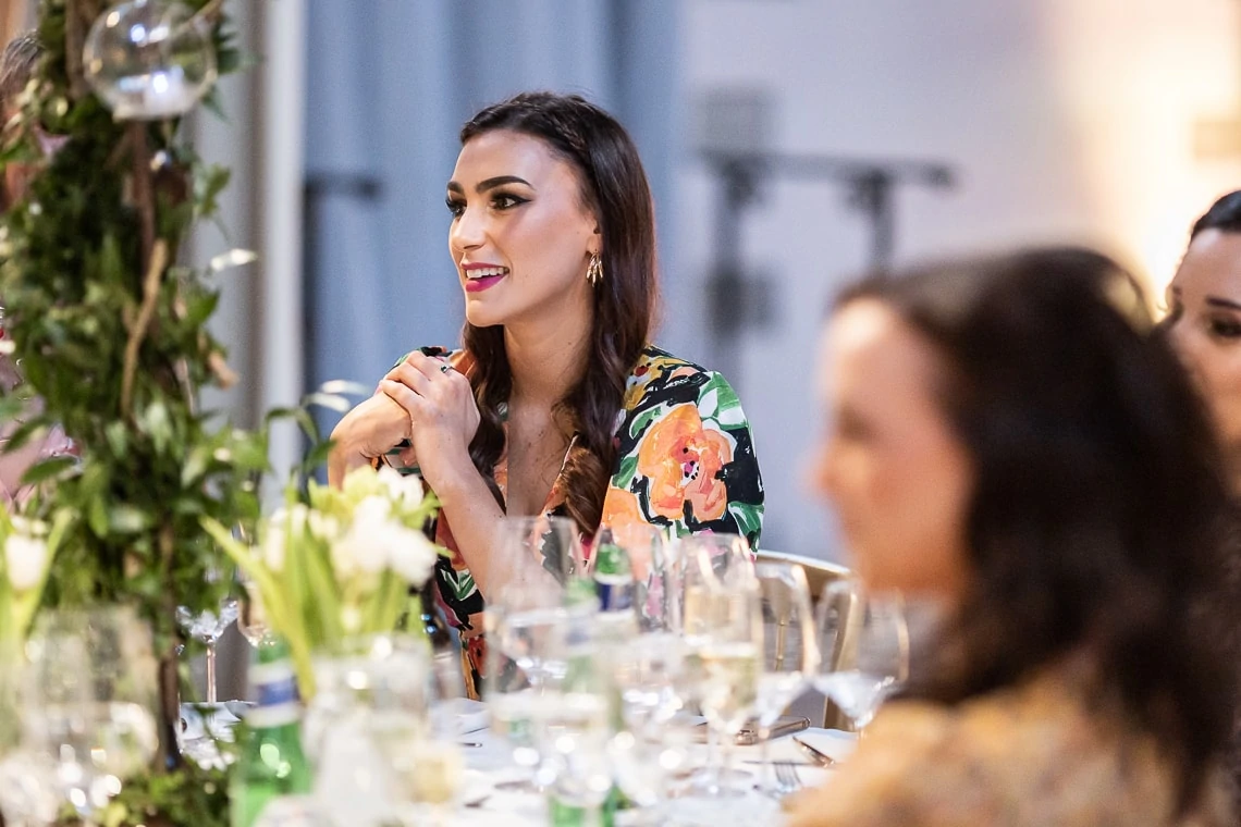 female guest smiles during father of the bride speech