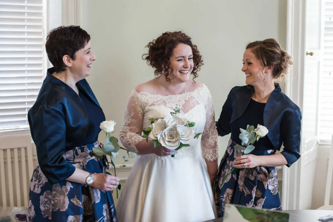 Bride and bridesmaids laughing before marriage ceremony