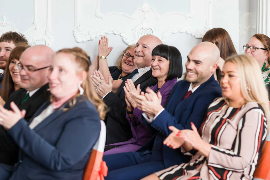 Guests clapping during the marriage ceremony in the MacMillan room at the Mansion House