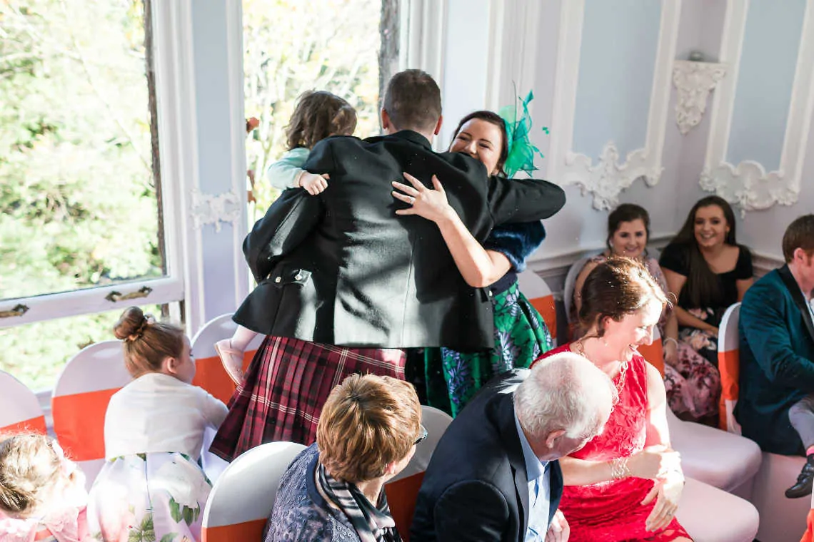 Guests cuddling at marriage ceremony in the MacMillan room of the Mansion House