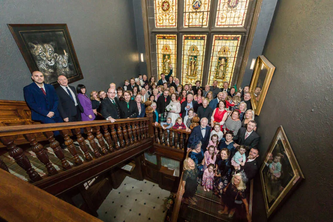 Entire wedding party on the staircase at the Mansion House at Edinburgh Zoo