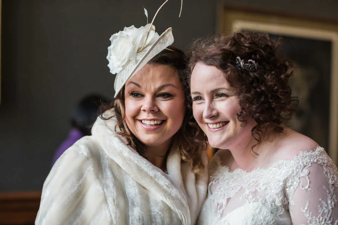 Bride and guest smiling for photo during drinks reception