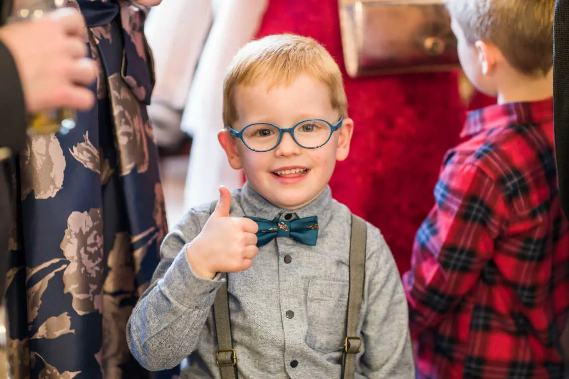 Boy wearing bow tie giving a thumbs up