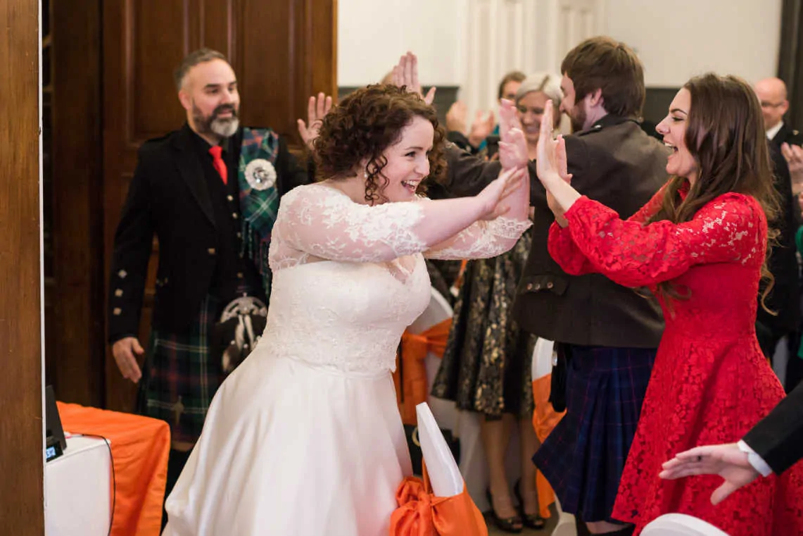 Bride and Groom giving guests high fives at wedding reception