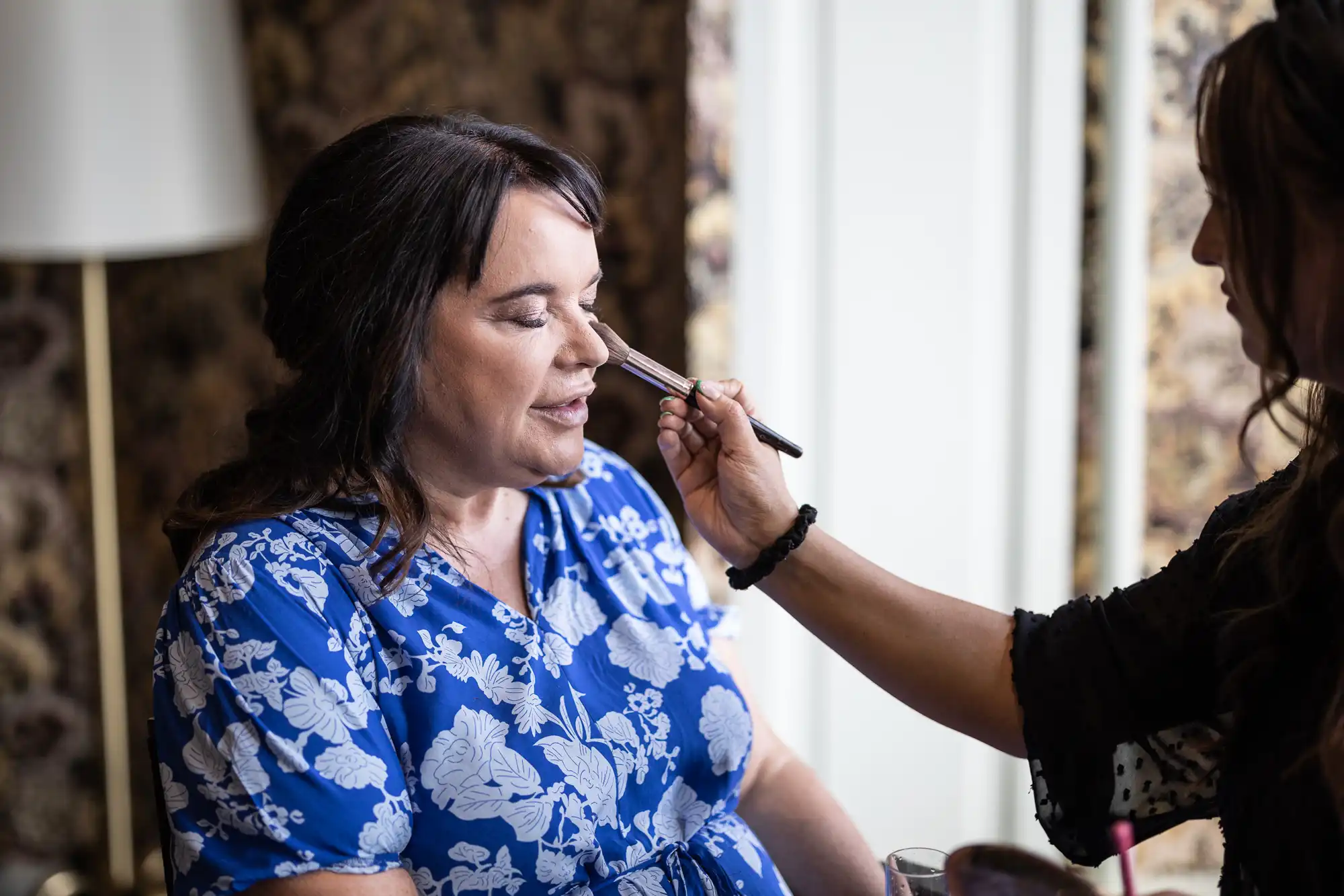 mother of the bride makeup being applied during pre-ceremony preparations