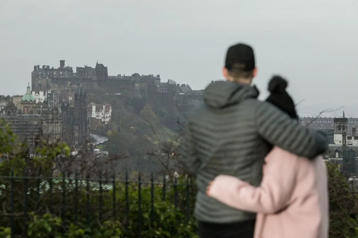 couple embrace with Edinburgh Castle in the background