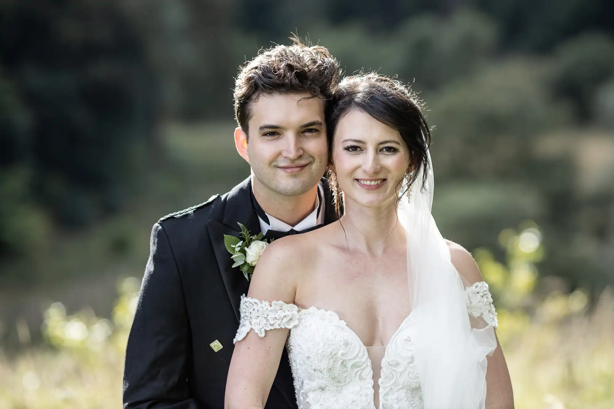 Neidpath Castle wedding photographer for a bride and groom smiling and standing close together outdoors on their wedding day.