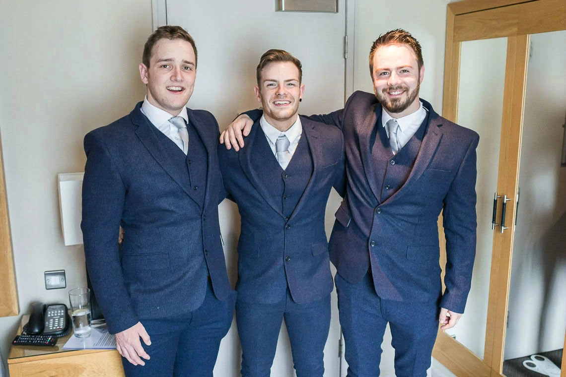 groomsmen photo wearing suits in hotel room