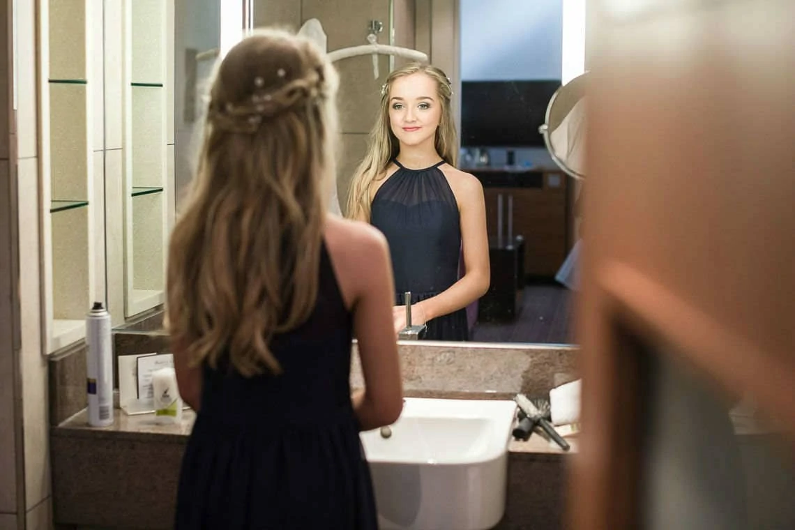 bridesmaid looking in mirror in hotel room