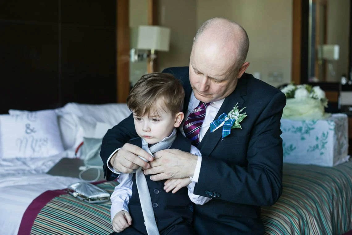 little boy getting his tie put on by his Grandpa