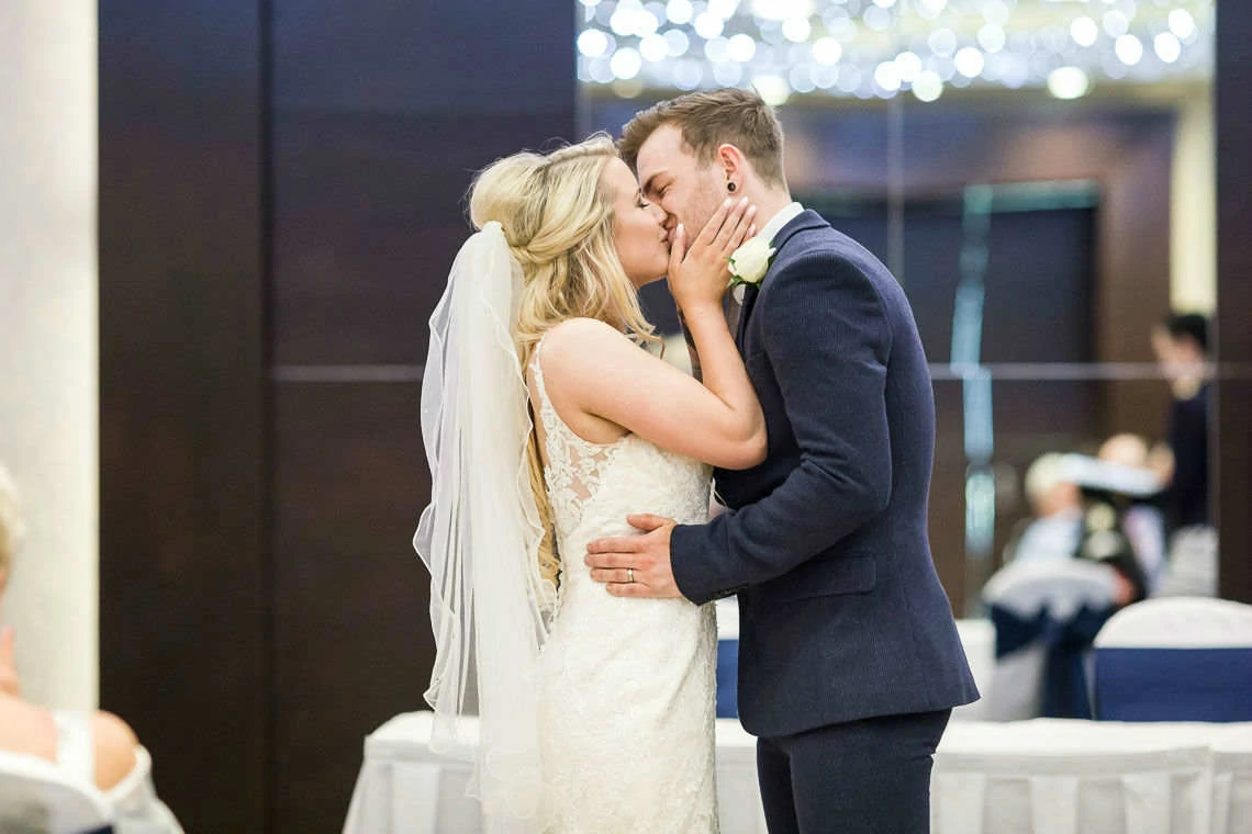 Bride and grooms first kiss at wedding ceremony
