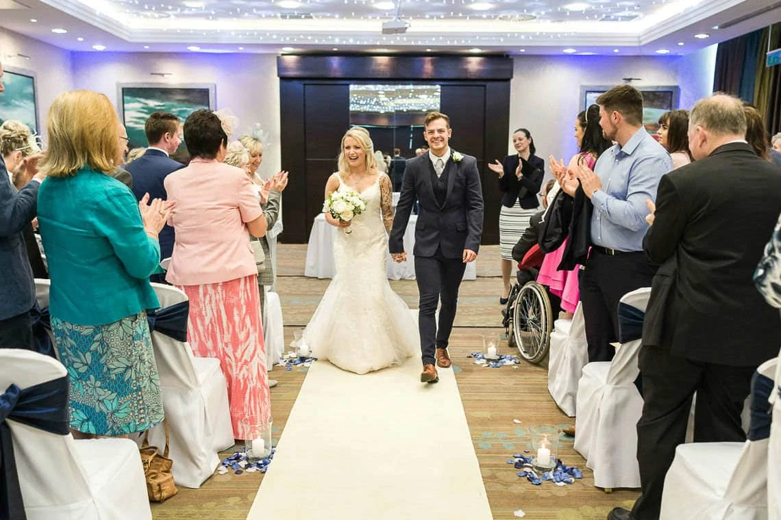 Bride and Groom walk down aisle hand in hand