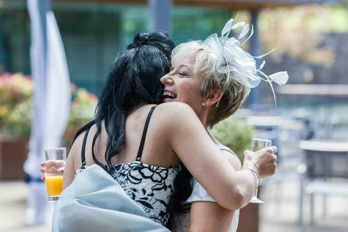 Mother of the bride cuddles wedding guest