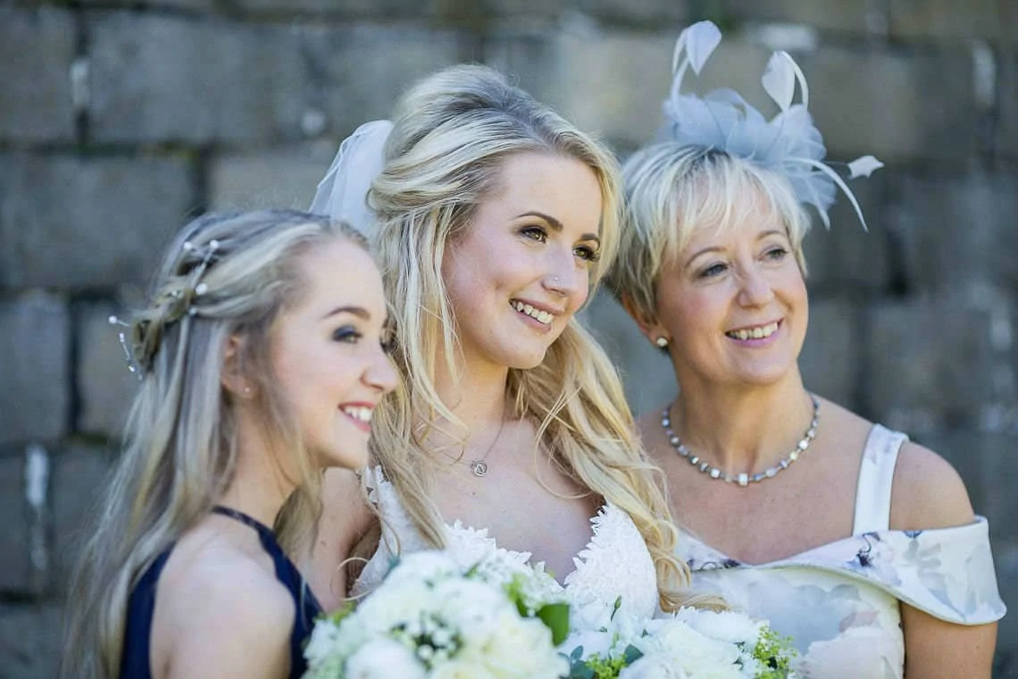 bride, bridesmaid and mother of the bride pose for photo