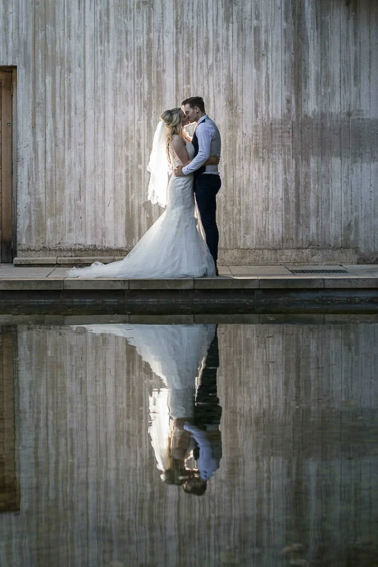 Garden Suite - newlyweds kissing in the evening in front of water feature