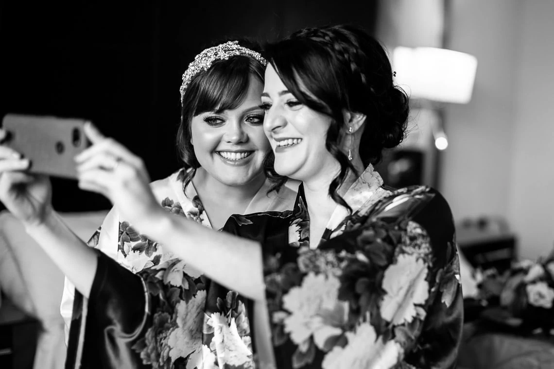 bride and bridesmaid taking a selfie during preparations