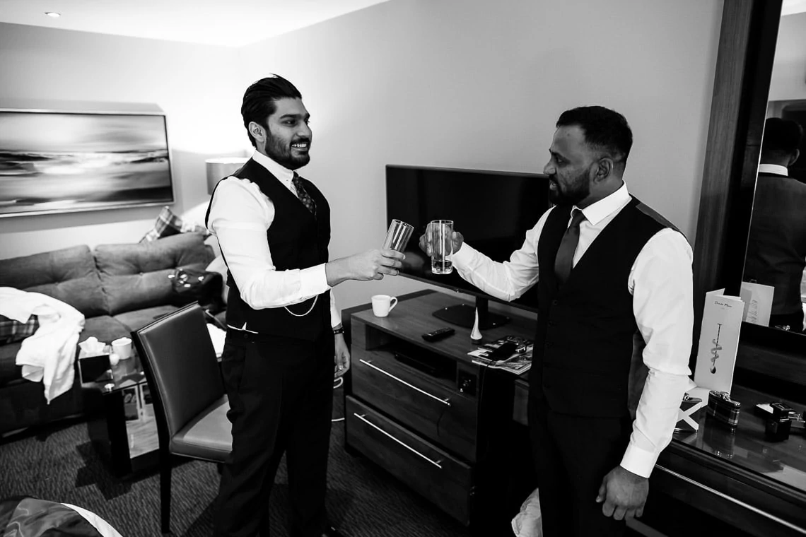 groom and best man toast a whisky