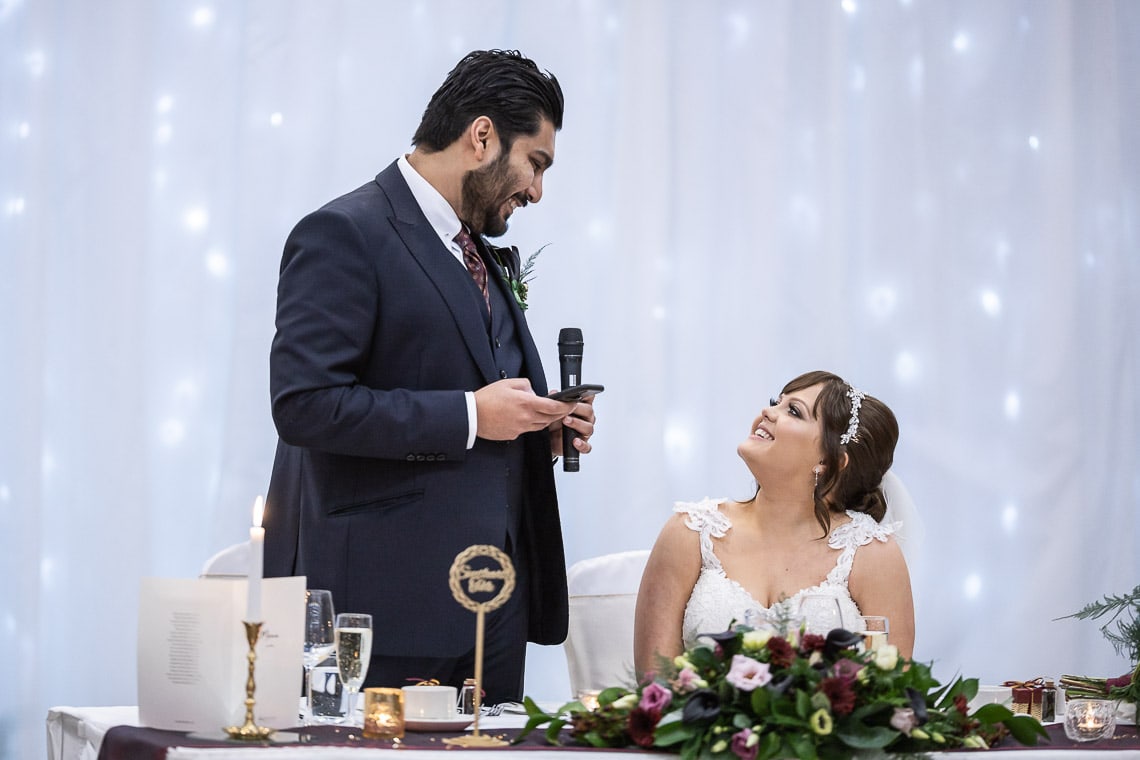 Groom looks at his bride during his speech
