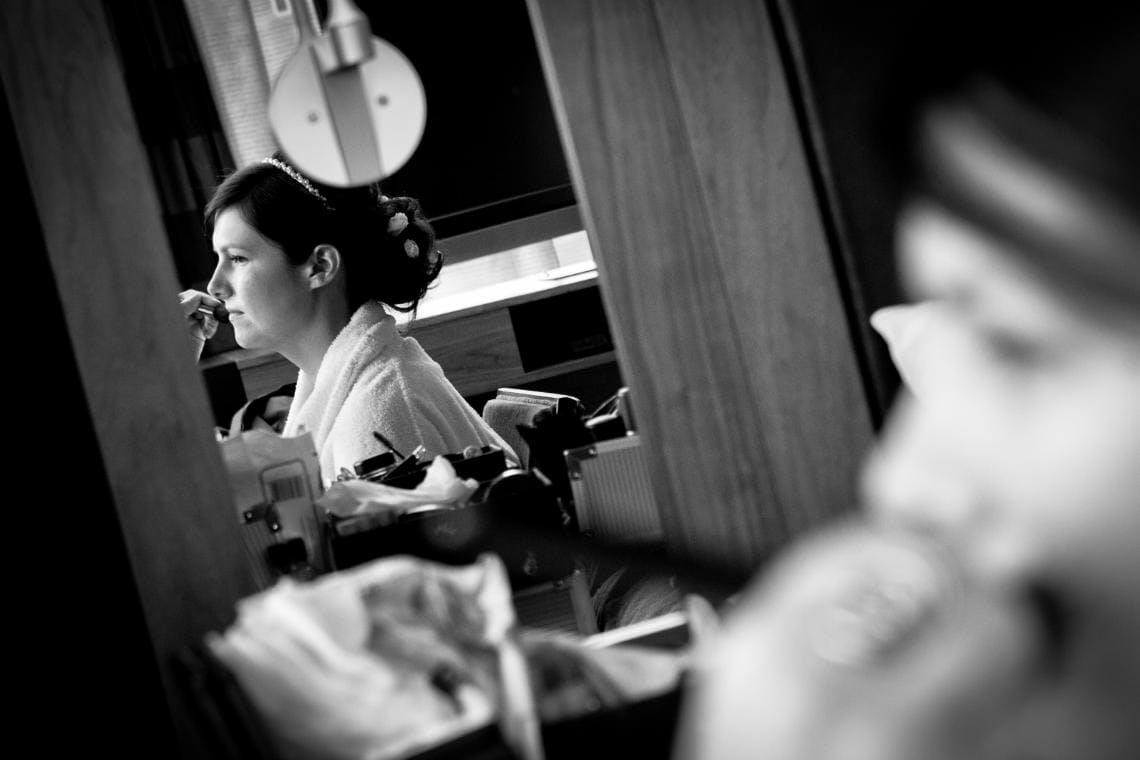 bride reflection in a mirror as makeup is applied