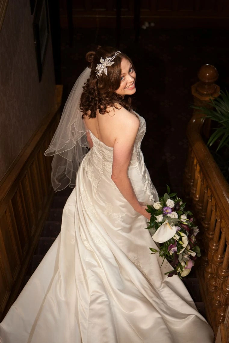 bride looking back over her shoulder on the staircase