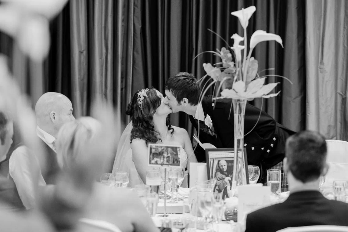 groom kisses his bride during his speech