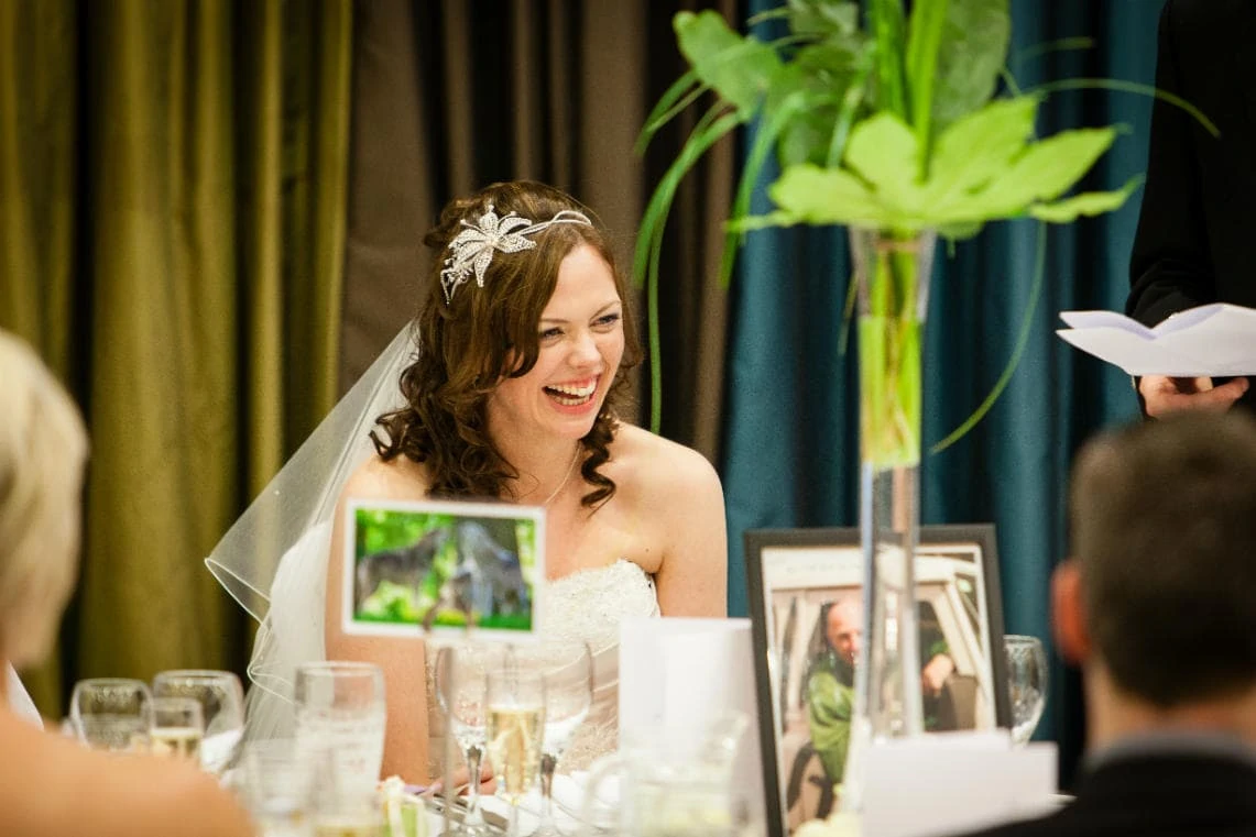 bride laughing during the groom's speech