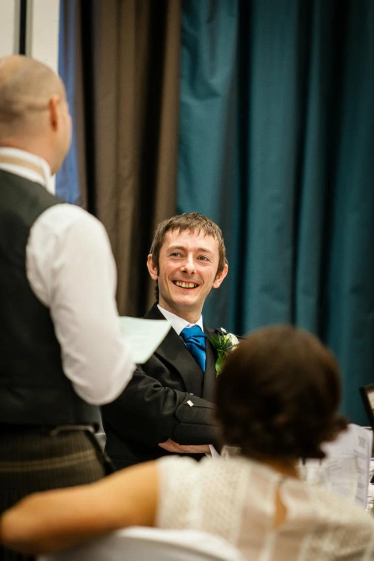 groom smiling during the best man speech
