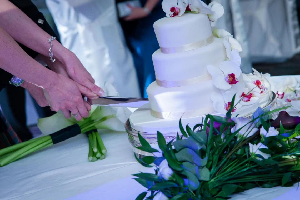 closeup of newlyweds cutting the cake