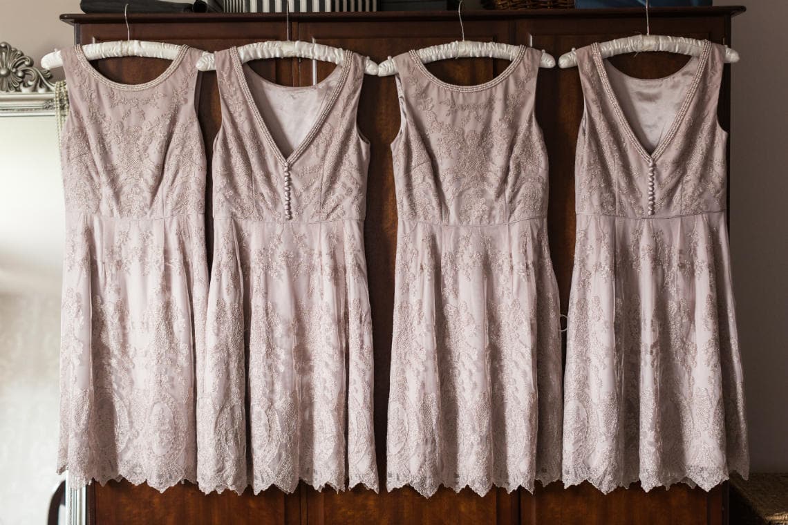 pale pink bridesmaid's dresses hanging up