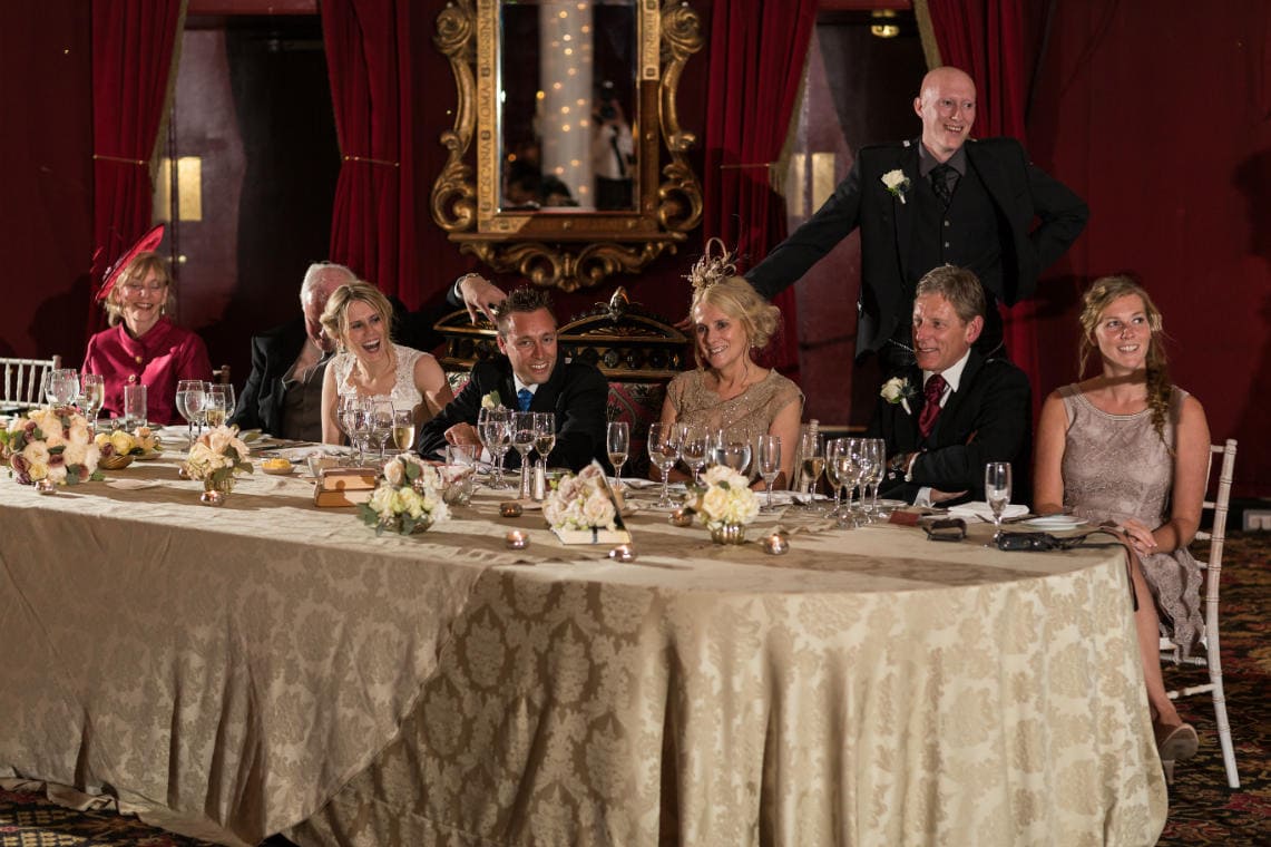 top table guests laughing during the best man's speech in the Stables Ballroom
