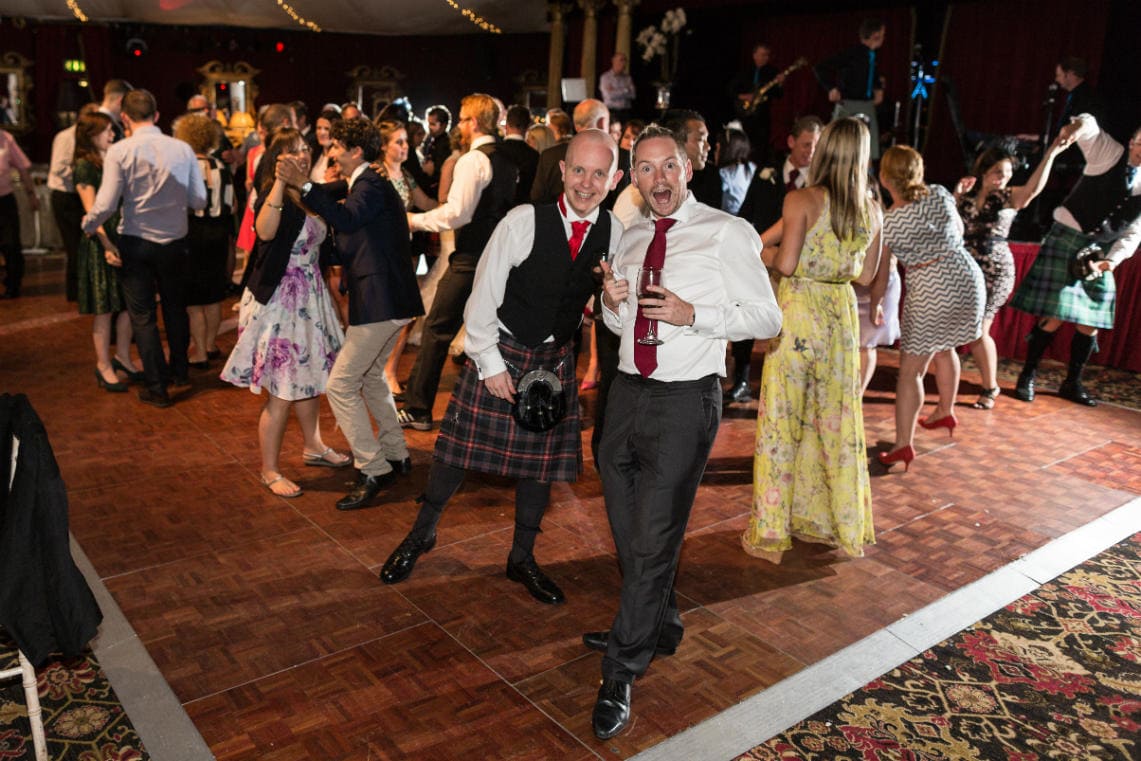 a couple of guests photobombing during the ceilidh dancing