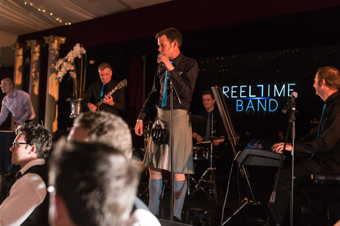 Reeltime Band on the stage calling ceilidh dancing in the Stables Ballroom
