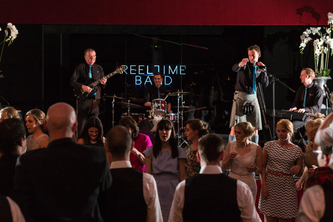 Reeltime Band on the stage calling ceilidh dancing in the Stables Ballroom