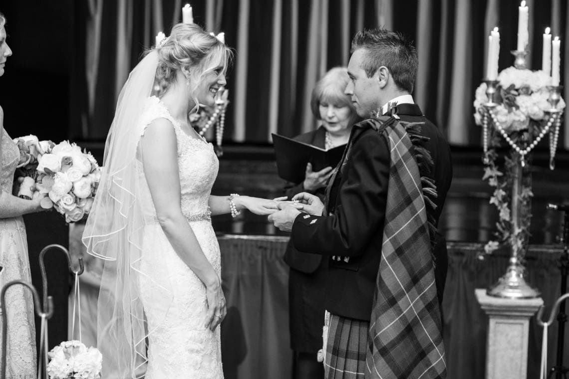 groom placing a ring on the bride's finger