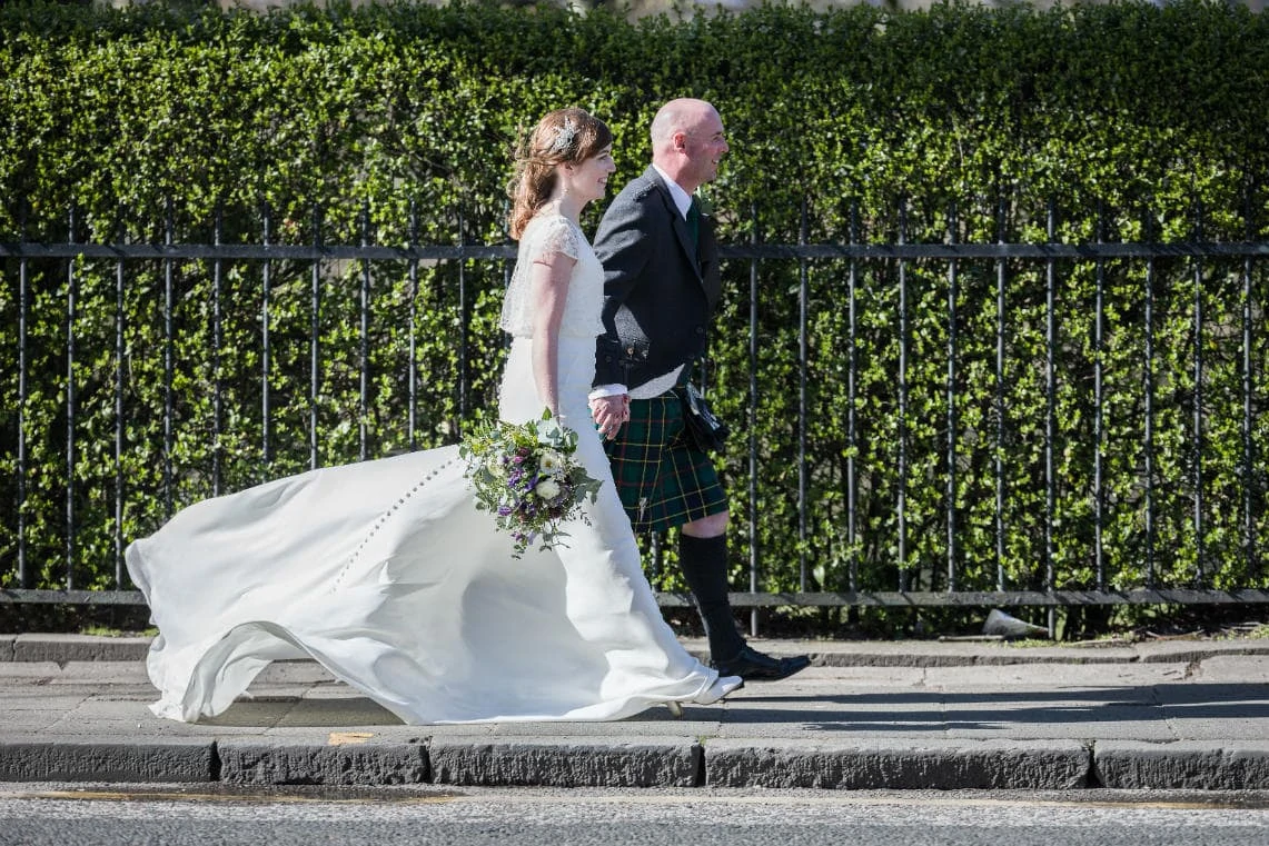 Queen Street newlyweds walking together bride's dress billowing