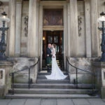 posed photo of newlyweds kissing outside wedding venue