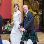 photo of bride and groom walking into wedding reception
