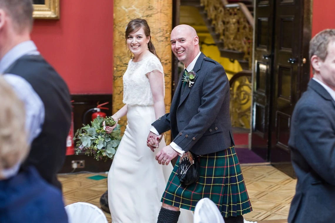 photo of bride and groom walking into wedding reception