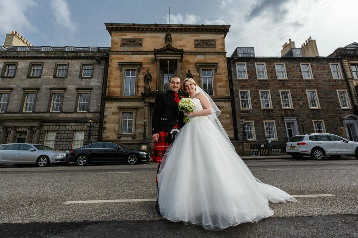 bride and groom on Queen Street outside Royal College of Physicians of Edinburgh